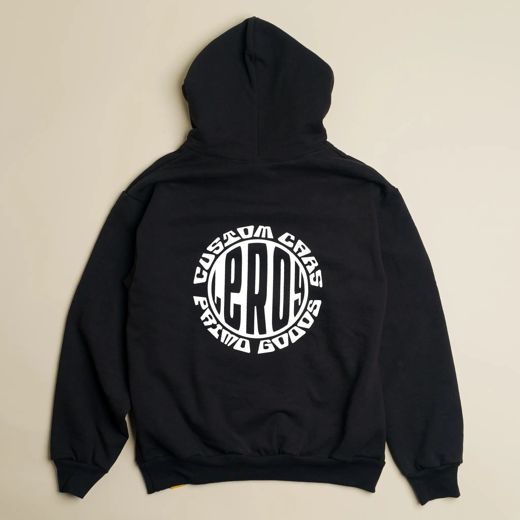 A black Primo Goods Heavy Weight Pullover Hoodie laid flat, featuring a large white circular graphic on the back with 'CUSTOM CARS', 'LEROY', and 'PRIMO GOODS' text.