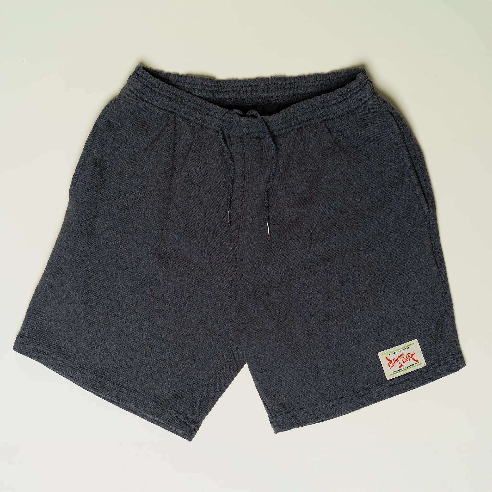 Dark gray fleece shorts laid flat on a light background, featuring a drawstring waistband and a small woven label on the lower left leg.