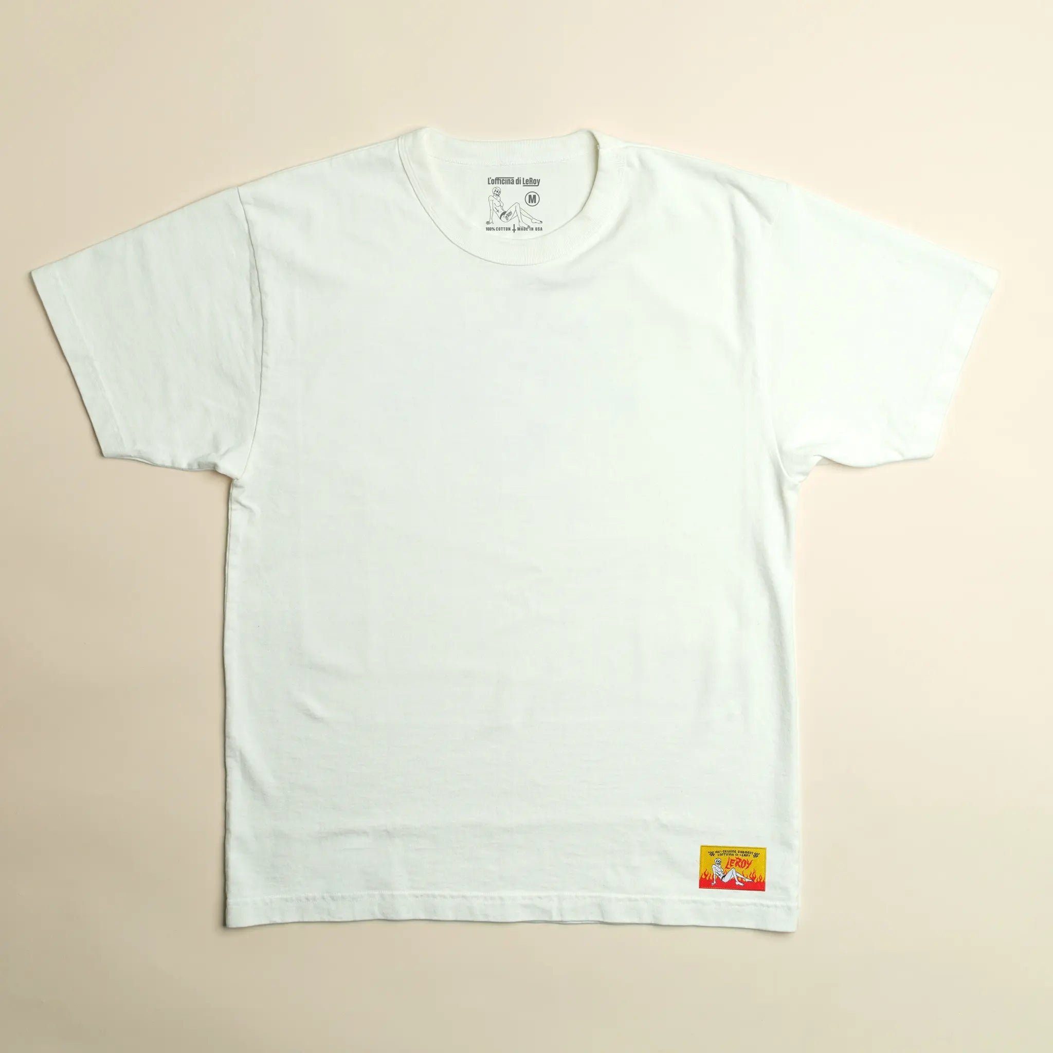 A white LeRoy Label Heavy Weight T-Shirt laid flat on a light background, featuring a small woven label with red lettering on the bottom right.