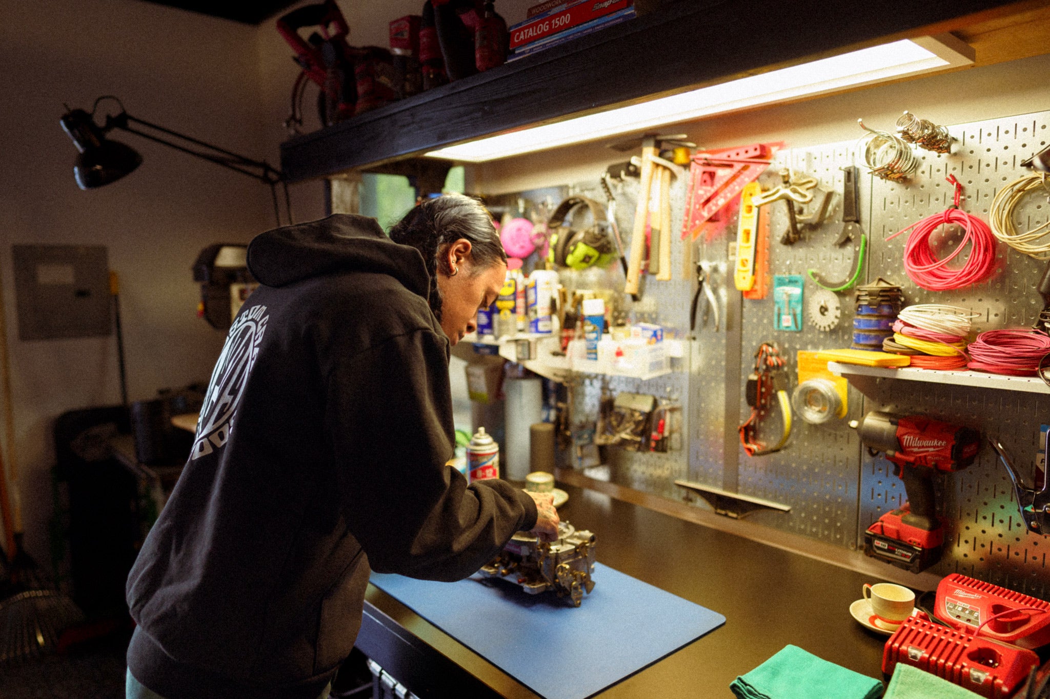Mechanic at a workbench, rebuilding an Edelbrock carburetor