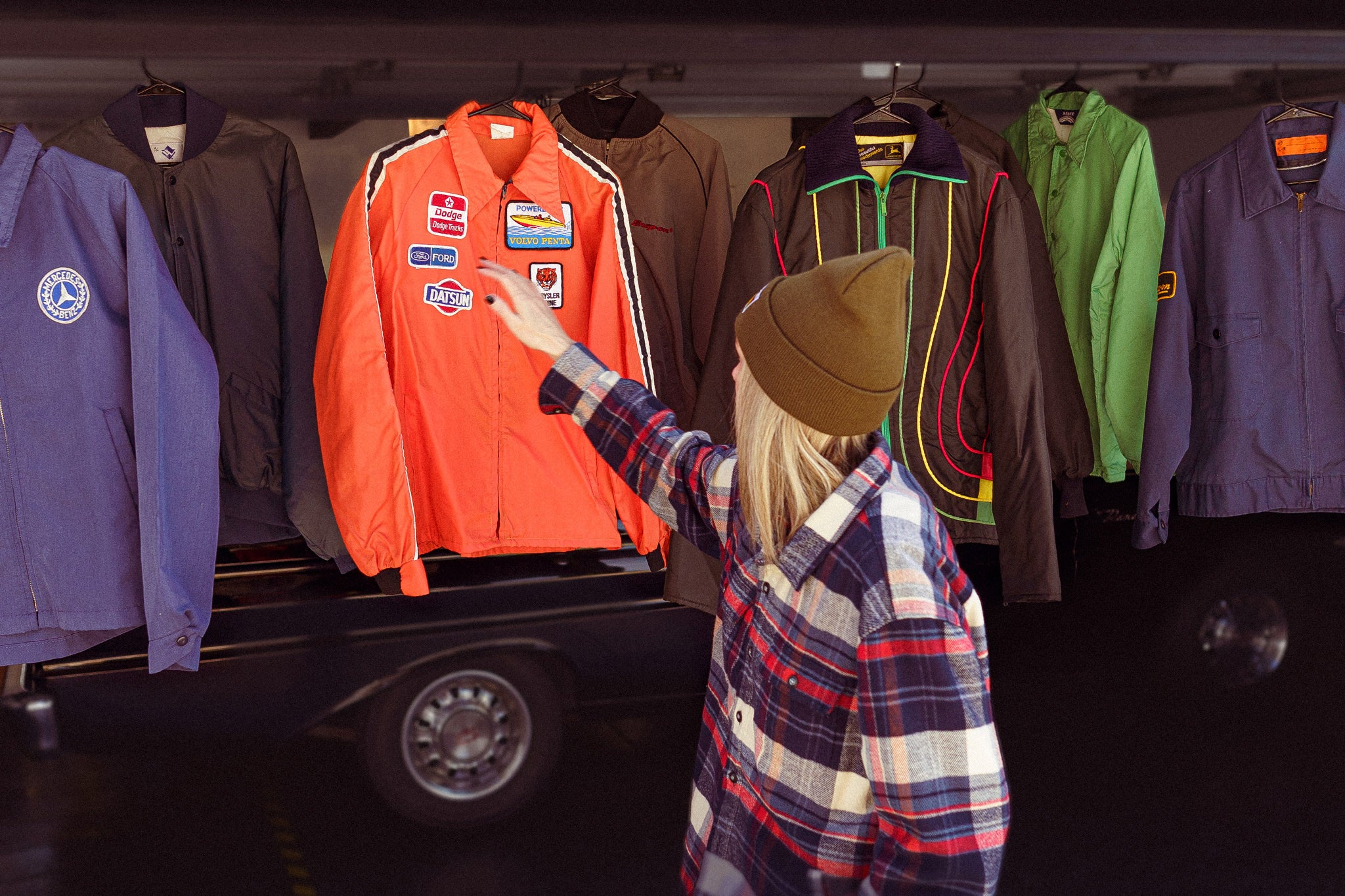 Woman arranging vintage jacket that is hanging from the top of the garage